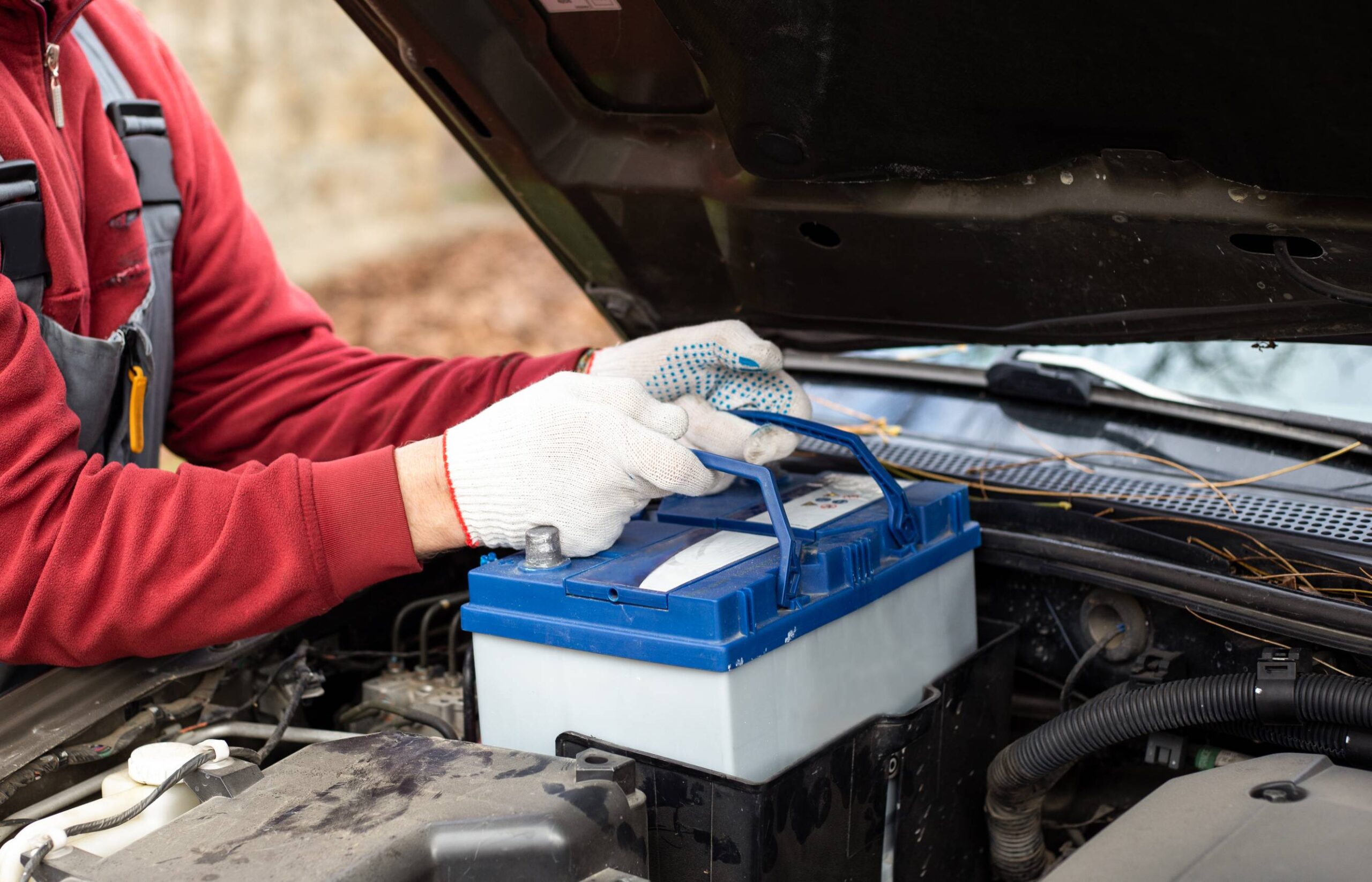 mechanic replaces the car battery. Discharging the battery and repairing the car